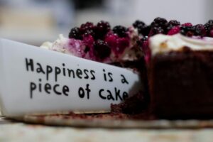 Home Slice of berry-topped cheesecake with a message plate saying
